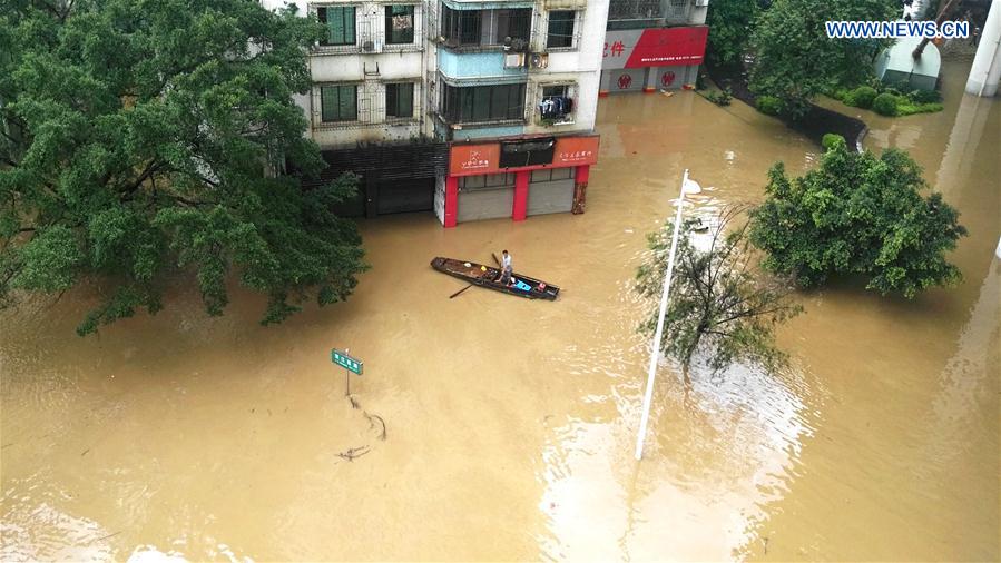 A resident rows a boat on the flooded Bingjiang West Road in Liuzhou, south China's Guangxi Zhuang Autonomous Region, June 16, 2016.