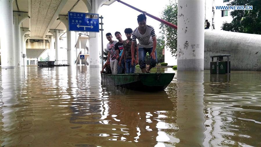 Residents stand on a boat on the flooded Bingjiang West Road in Liuzhou, south China's Guangxi Zhuang Autonomous Region, June 16, 2016. 