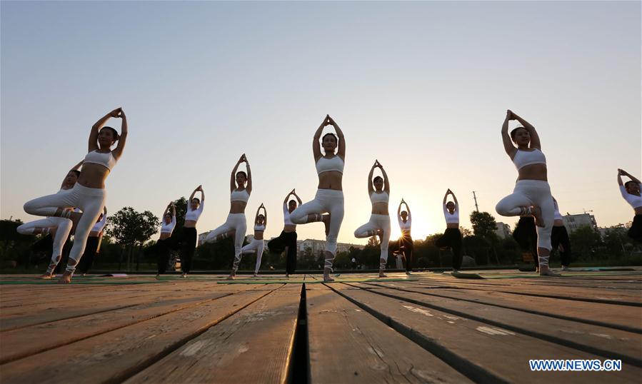 People practise yoga at the Longquan Lake Park in Wuzhi County of Jiaozuo, central China's Henan Province, June 18, 2016. 