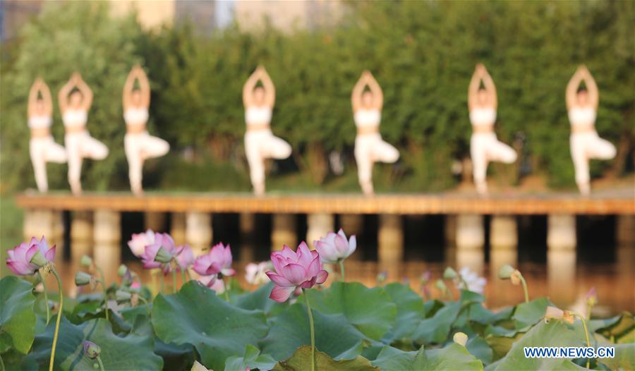 practise yoga at the Longquan Lake Park in Wuzhi County of Jiaozuo, central China's Henan Province, June 18, 2016. 