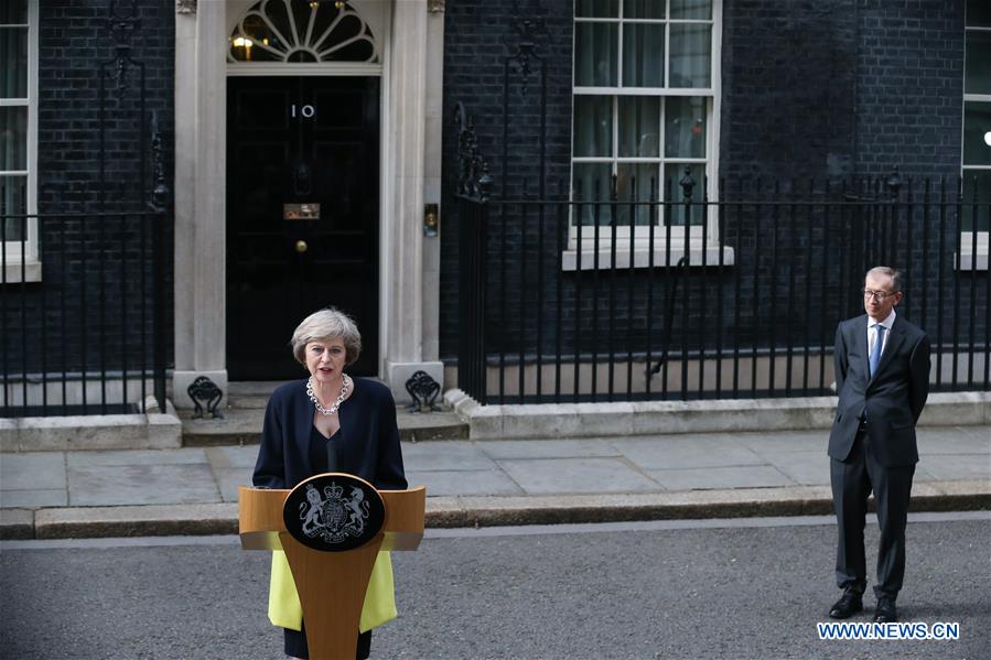 Britain's new Prime Minister Theresa May(L) and her husband pose for photos in front of 10 Downing Street in London, Britain on July 13, 2016.