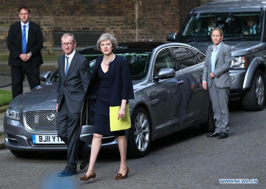 Britain's new Prime Minister Theresa May(L) and her husband pose for photos in front of 10 Downing Street in London, Britain on July 13, 2016.