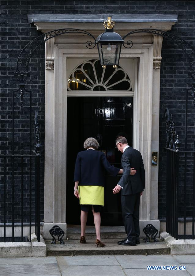 Britain's new Prime Minister Theresa May(L) and her husband pose for photos in front of 10 Downing Street in London, Britain on July 13, 2016.