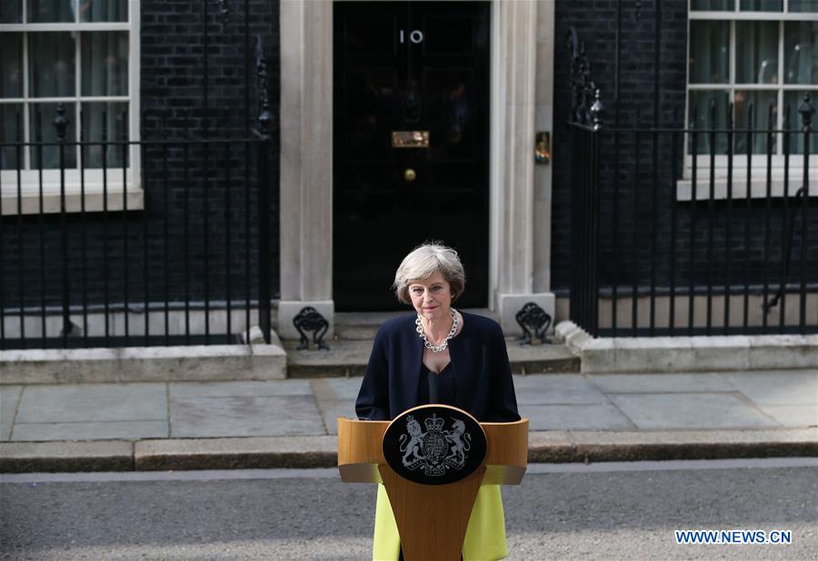 Britain's new Prime Minister Theresa May(L) and her husband pose for photos in front of 10 Downing Street in London, Britain on July 13, 2016.