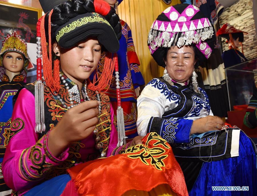 A folk artist paints on a lacquer during an intangible cultural heritage show of Liangshan Yi Autonomous Prefecture, in Xichang, southwest China's Sichuan Province, July 26, 2016. 