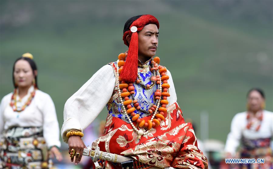 A model presents traditional Tibetan costumes during a fashion show held at Batang grassland of Yushu City of Yushu Tibetan Autonomous Prefecture, northwest China's Qinghai Province, July 26, 2016.