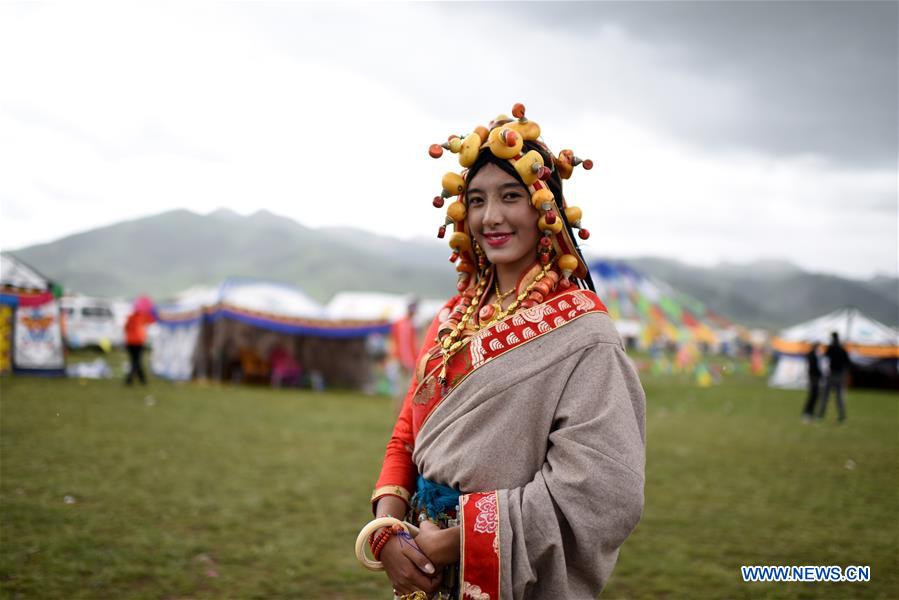 A model presents traditional Tibetan costumes during a fashion show held at Batang grassland of Yushu City of Yushu Tibetan Autonomous Prefecture, northwest China's Qinghai Province, July 26, 2016.