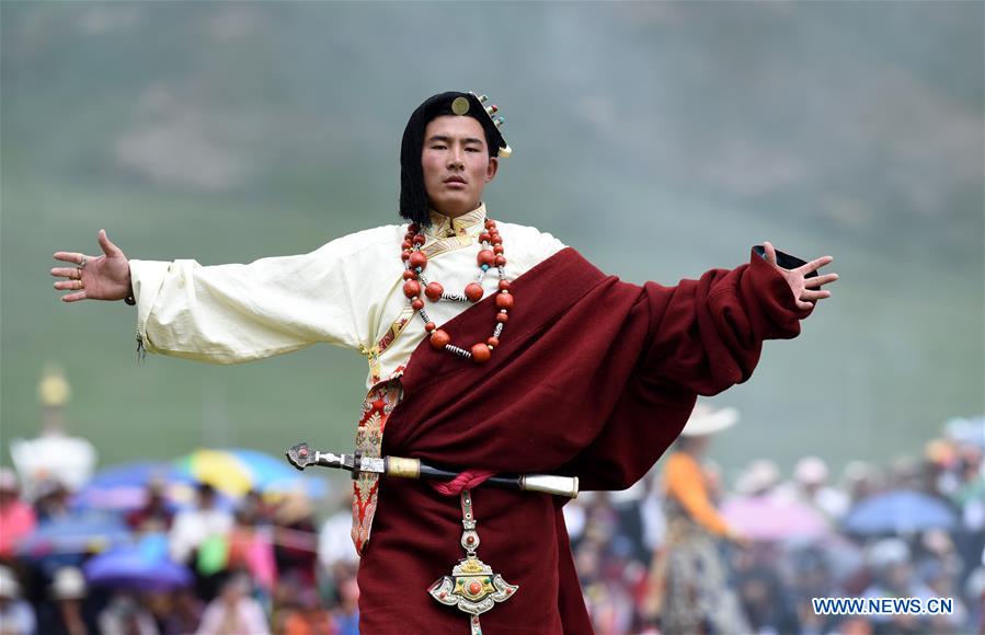 A model presents traditional Tibetan costumes during a fashion show held at Batang grassland of Yushu City of Yushu Tibetan Autonomous Prefecture, northwest China's Qinghai Province, July 26, 2016.