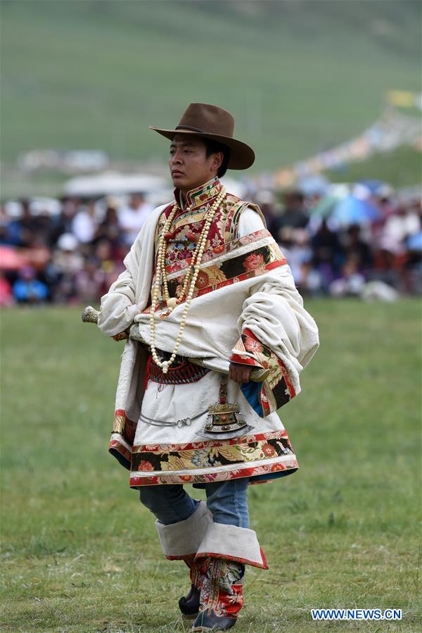 A model presents traditional Tibetan costumes during a fashion show held at Batang grassland of Yushu City of Yushu Tibetan Autonomous Prefecture, northwest China's Qinghai Province, July 26, 2016.