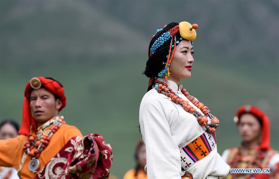 A model presents traditional Tibetan costumes during a fashion show held at Batang grassland of Yushu City of Yushu Tibetan Autonomous Prefecture, northwest China's Qinghai Province, July 26, 2016.