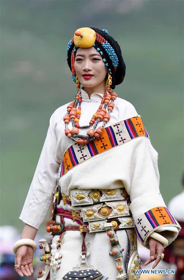 A model presents traditional Tibetan costumes during a fashion show held at Batang grassland of Yushu City of Yushu Tibetan Autonomous Prefecture, northwest China's Qinghai Province, July 26, 2016.