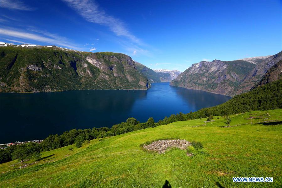 Tourists take a boat to appreciate a waterfall at Geirangerfjord in Norway, July 20, 2016.