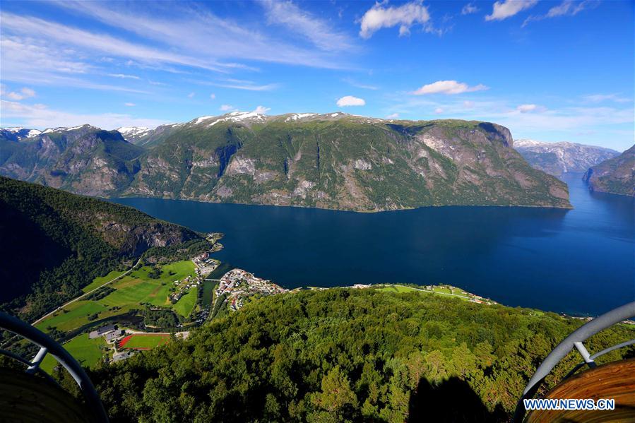 Tourists take a boat to appreciate a waterfall at Geirangerfjord in Norway, July 20, 2016.