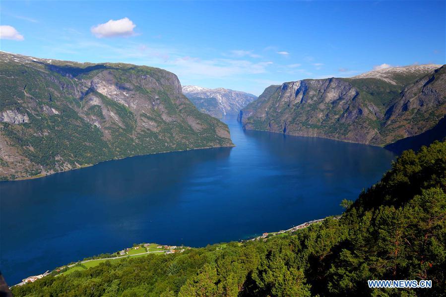 Tourists take a boat to appreciate a waterfall at Geirangerfjord in Norway, July 20, 2016.