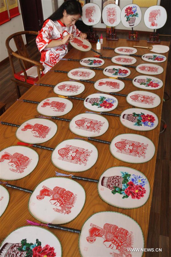 Liang has made over 40 kinds of handiworks of paper cutting as she combined the cutting with porcelain, statue, cloth and etc.