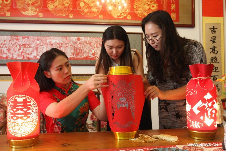 Liang has made over 40 kinds of handiworks of paper cutting as she combined the cutting with porcelain, statue, cloth and etc.