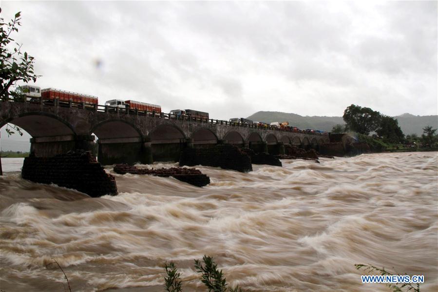 People watch the search operation in the flooded Savitri river after an old bridge collapsed due to torrential rain in Mahad, Indian state of Maharashtra, Aug. 3, 2016. 