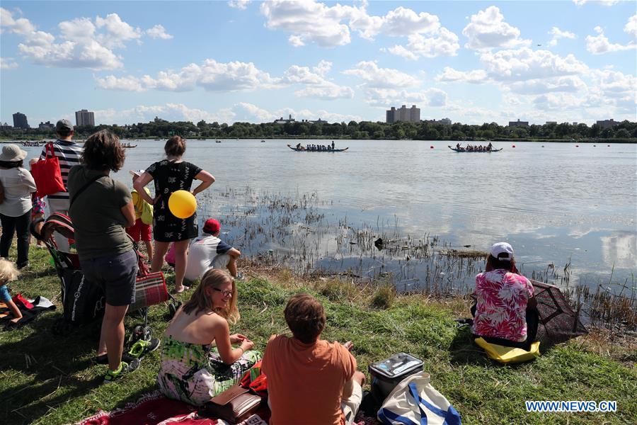 Dragon boat players cheer for the completion of a competition during the Hong Kong Dragon Boat Festival in New York (HKDBF-NY) held in Corona Park of New York, the United States, Aug. 7, 2016.