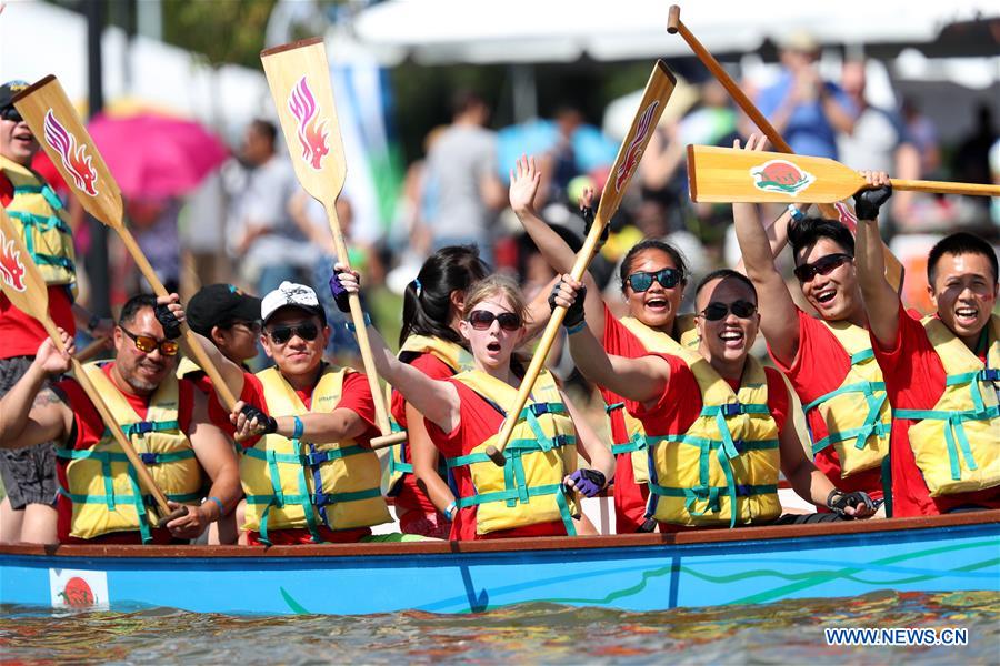 Dragon boat players cheer for the completion of a competition during the Hong Kong Dragon Boat Festival in New York (HKDBF-NY) held in Corona Park of New York, the United States, Aug. 7, 2016.