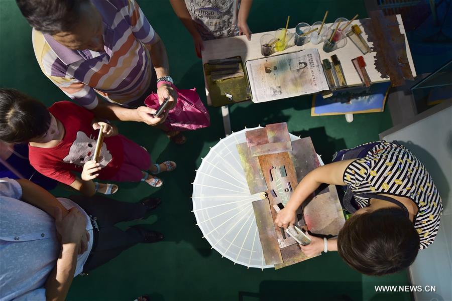 Traditional materials and tools used for making silk umbrellas are displayed during a West Lake silk umbrella show in Hangzhou, capital of east China's Zhejiang Province, Aug. 26, 2016. 