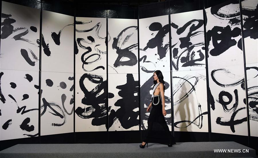 A model presents a creation with Chinese calligraphy elements during a fashion show in Taipei, southeast China's Taiwan, Oct. 12, 2016. 