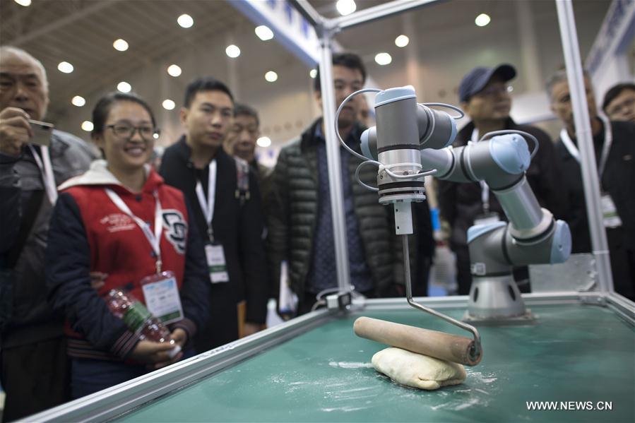 Visitors view a robot at the 13th Optics Valley of China International Optoelectronic Exposition and Forum in Wuhan, capital of central China's Hubei Province, Nov. 3, 2016.