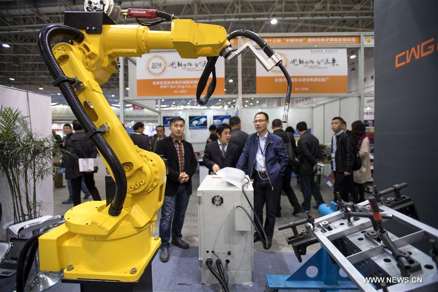 Visitors view a robot at the 13th Optics Valley of China International Optoelectronic Exposition and Forum in Wuhan, capital of central China's Hubei Province, Nov. 3, 2016.