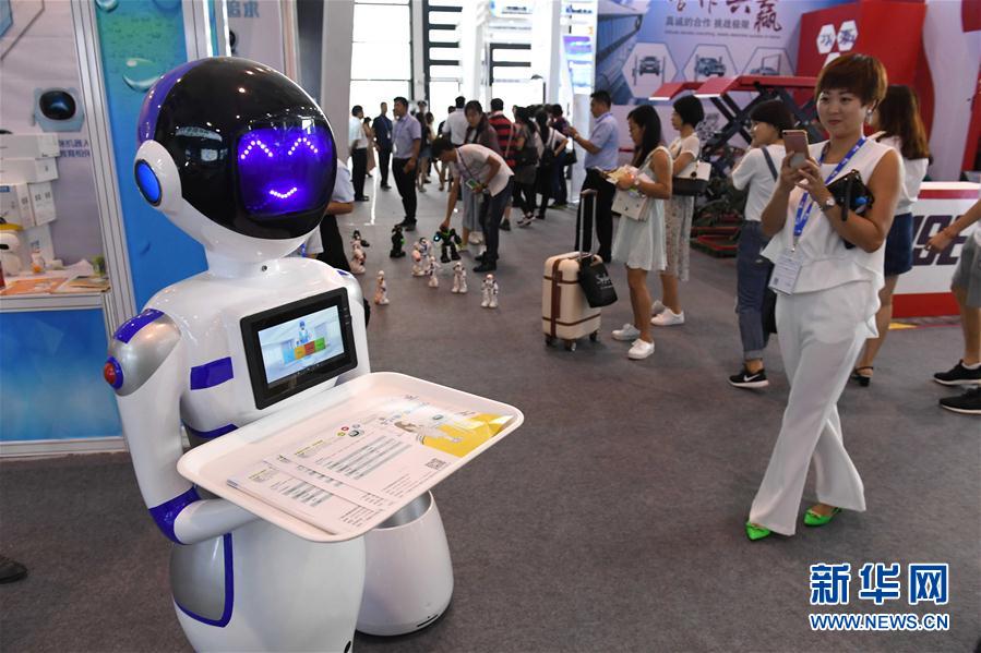 9月12日，参观者在南宁国际会展中心关注一款机器人服务员。