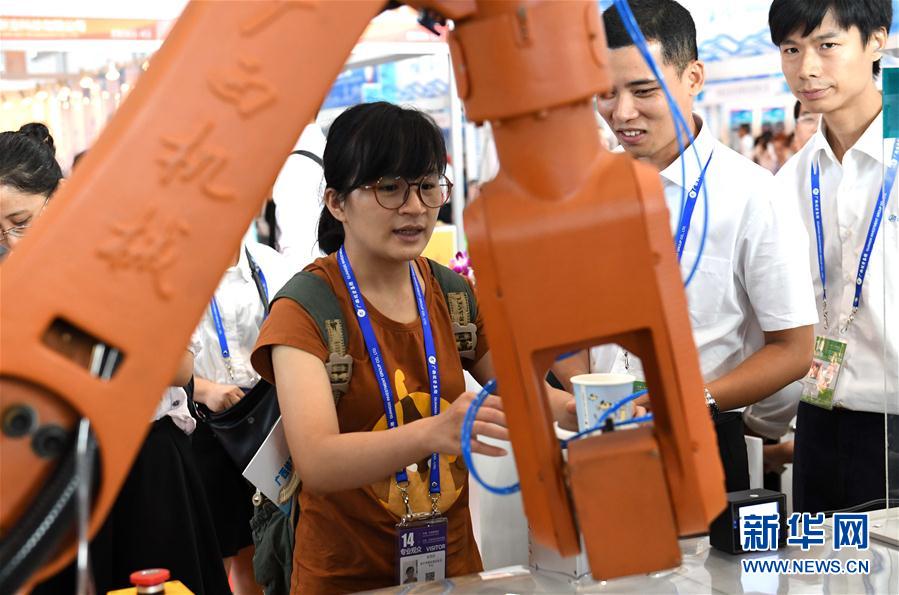 9月12日，在南宁国际会展中心，一款智能机器臂为参观者送橙汁。