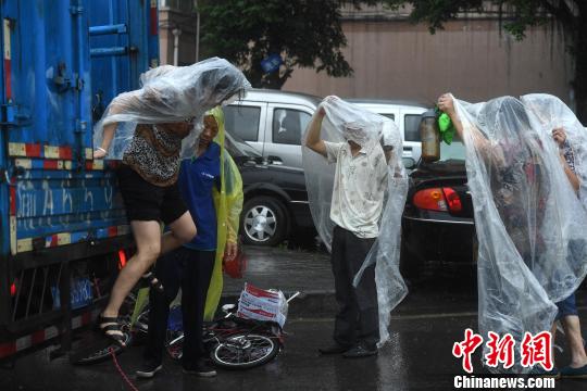 图为重庆突降暴雨民众穿着自制雨衣。陈超 摄