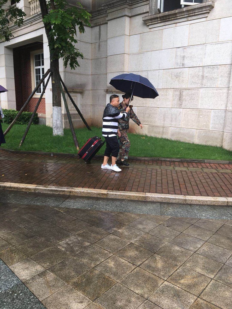 成都一学校老师暴雨中筑人墙撑伞为学生护行