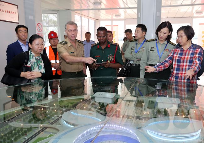 Officials of the International Military Sports Council (CISM) stand in front of a sand table during a visit to the Dongxihu Sports Center on October 9, 2018 to inspect the progress of the project. [Photo: Changjiang Daily]