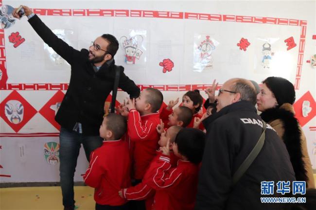 Abdelhalim Elwerdany of Egypt's Al-Gomhuria newspaper takes selfie with children from a village kindergarten in Hotan. [Photo: Xinhua] 