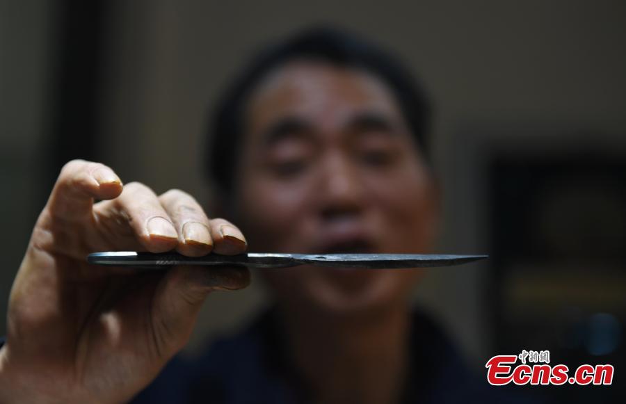 Craftsman Ding Jican makes Zhang Xiaoquan scissors using traditional methods in Hangzhou City, East China\'s Zhejiang Province, March 18, 2019. Zhang Xiaoquan scissors are a famous brand with a long history in China, and Ding has been committed to making the household utensil for 40 years. Ding himself is a master of the Zhang Xiaoquan scissor-making techniques, which have been perfected over the centuries and are recognized in China as a state intangible cultural heritage. (Photo: China News Service/Wang Gang)