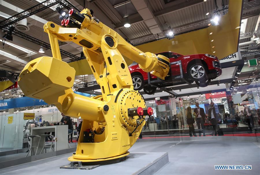 A robotic arm lifts a vehicle at the booth of FANUC during the 2019 Hanover Fair in Hanover, Germany, on April 1, 2019. With a total of 6,500 exhibitors from 75 countries and regions, the Hanover Fair shows the latest development of technologies for industrial use, including 5G network, artificial intelligence, light-weight manufacturing among others. (Xinhua/Shan Yuqi)