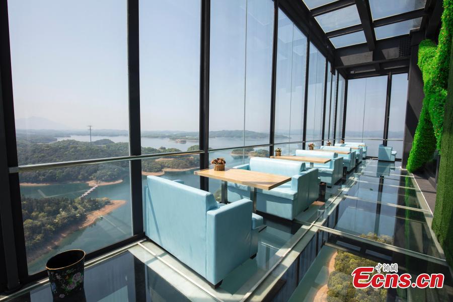 A view of a café inside a glass sightseeing tower, 99 meters above the ground, in Lushan Xihai scenic area in Yongxiu County, East China\'s Jiangxi Province, April 7, 2019. Visitors to the tower can enjoy great views of the mountain and lake. (Photo: China News Service/Zhang Haiyan)