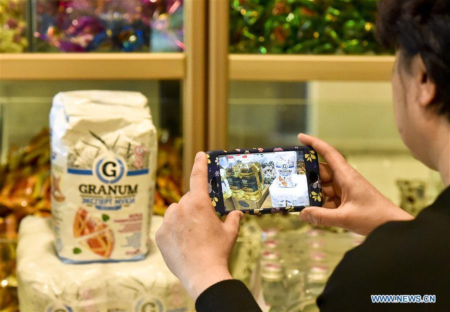 A food vender takes photos of oil and flour imported from Kazakhstan at a store for imported food in Urumqi, northwest China\'s Xinjiang Uygur Autonomous Region, April 12, 2017. Food of a particular place is an important symbol of local geographic and cultural characteristics. Food carries history and tradition, leads the tide of trade, strengthens diplomatic relations, disseminates and promotes culture. Food has been serving as connections between people around the world. In ancient times, food such as grapes, pomegranates, walnuts, coriander, cucumbers and sesame seeds were introduced to China along the Silk Road. Nowadays, thanks to the Belt and Road Initiative, red wine, coffee, dried fruits, meat, seafood, and dairy products from foreign countries enter the homes of ordinary people, turning daily meals into feasts with exotic cuisines. (Xinhua/Hu Huhu)