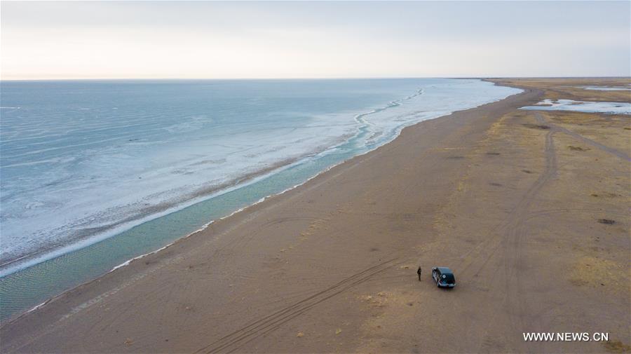 Aerial photo taken on April 14, 2019 shows Shuanglong, a man of Mongolian ethnic group, standing along the Hulun Lake in the Hulun Buir City, north China\'s Inner Mongolia Autonomous Region. Shuanglong, a volunteer born in the 1980s, has been dedicated to protecting wildlife inhabiting along the Hulun Lake over the past ten years. Over 40 endangered animals have been saved through his efforts. Shuanglong has organized various activities including photo exhibitions and lectures, as a way to raise awareness of wildlife protection among the public. Affected by Shuanglong, some volunteers also joined him to protect wildlife along the Hulun Lake. (Xinhua/Peng Yuan)