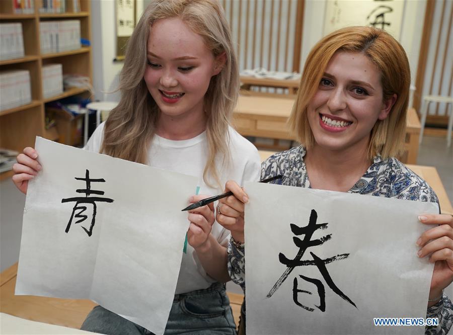 Sara Davlatova (R) from Tajikistan and Aruzhan Kossay from Kazakhstan shows the Chinese characters they wrote in Nanjing, capital of east China\'s Jiangsu Province, April 28, 2019. A cultural exchange event between young representatives from Nanjing and foreign students from Nanjing University of the Arts was held in Nanjing. (Xinhua/Ji Chunpeng)