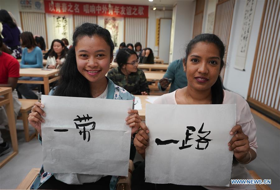 Roxane Estelle Firmin (R) from Mauritus and Nomena Andrianian Razafindrakoto from Madagascar shows the Chinese characters they wrote in Nanjing, capital of east China\'s Jiangsu Province, April 28, 2019. A cultural exchange event between young representatives from Nanjing and foreign students from Nanjing University of the Arts was held in Nanjing. (Xinhua/Ji Chunpeng)