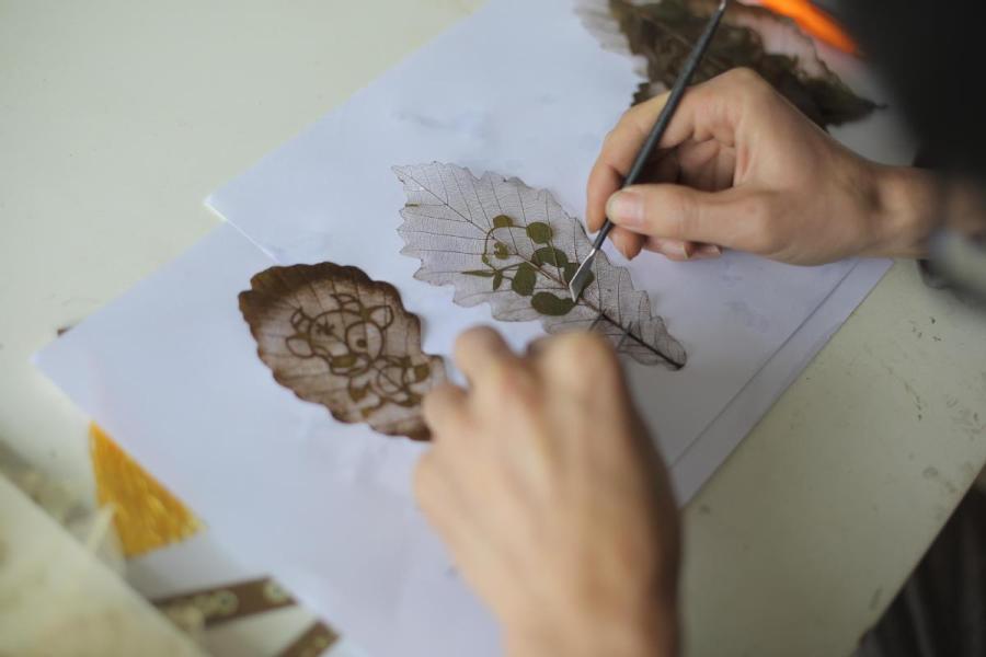 Deng Weiwei from Southwest China\'s Chongqing works on a leaf carving. At the recent International Handicrafts Trade Fair in Florence, Italy, Deng\'s work attracted considerable attention. (Photo provided to chinadaily.com.cn)