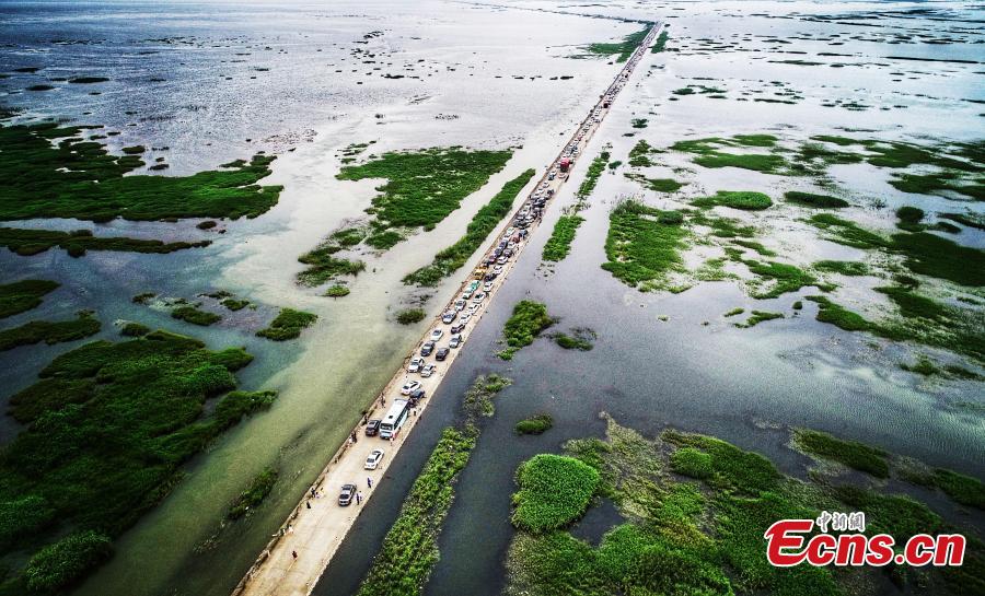 Photo taken on June 16, 2019 shows the submerged Dahuchi section of Yongxiu-Wucheng Road in East China\'s Jiangxi province. Continuous rain in Jiangxi has led to a rise of water level of the Poyang Lake, China\'s largest freshwater lake. The Dahuchi section of Yongxiu-Wucheng Road was submerged in water. (Photo: China News Service/Mao Jiajia)