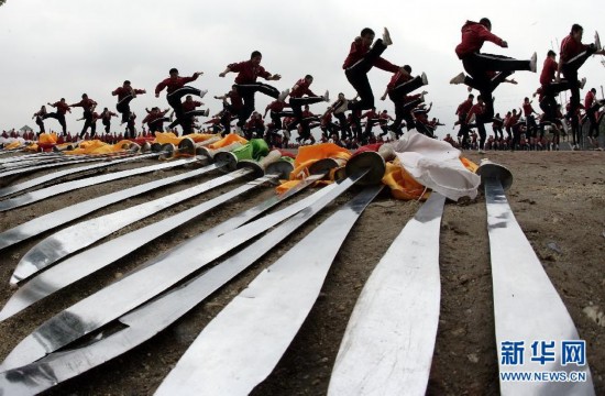 一所少林武校的学员们在练功场上练习"旋风腿"(2008年4月21日摄).