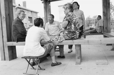 图为老人们在改建后的小区内聊天.