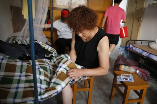 2013年08月31日,湖北省武汉市,中国地质大学,一位母亲为孩子缝被套.