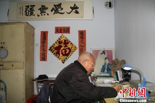 图为王殿贵老人向社区主任赠送图书,希望人们可以传阅学习.