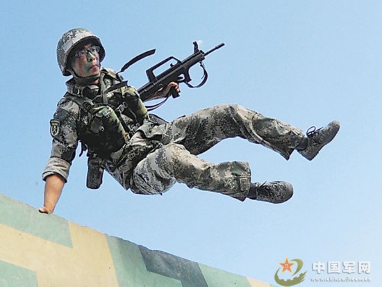 图为全副武装飞越障碍.