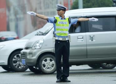 7月28日,成都交警三分局民警陈思鸿在路口指挥交通.