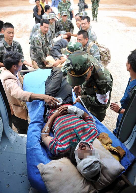 8月4日,在鲁甸县龙头山镇,救援人员将受伤人员向昭通转移.