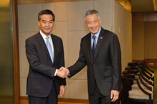梁振英(左)在吉隆坡与新加坡总理李显龙(右)于会面前握手.